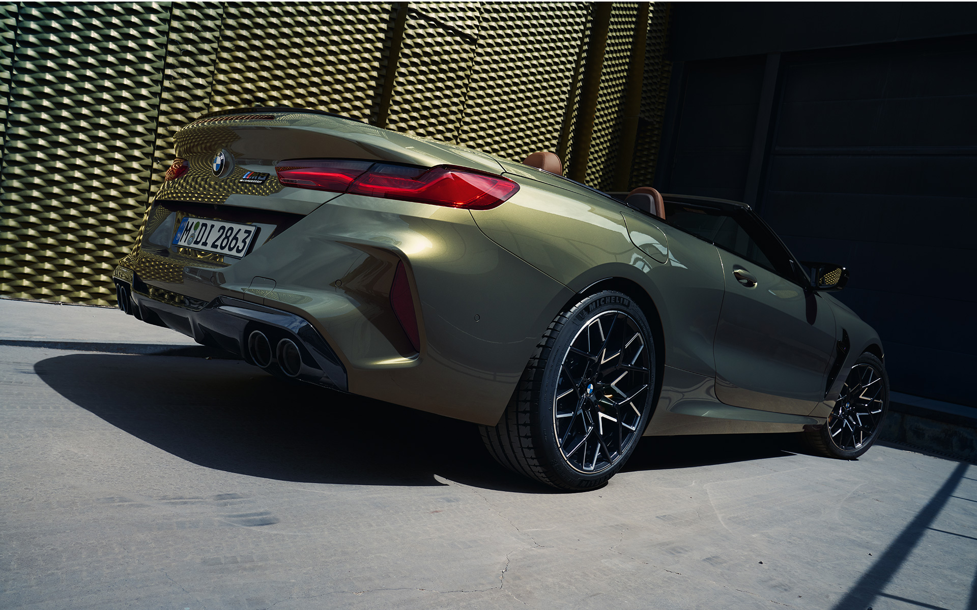 Вид ззаду на три чверті BMW M8 Competition Cabrio F91 LCI Facelift 2022 BMW M8 Competition Cabrio F91 LCI Facelift 2022 кольору BMW Individual Brass metallic, вид ззаду знизу
