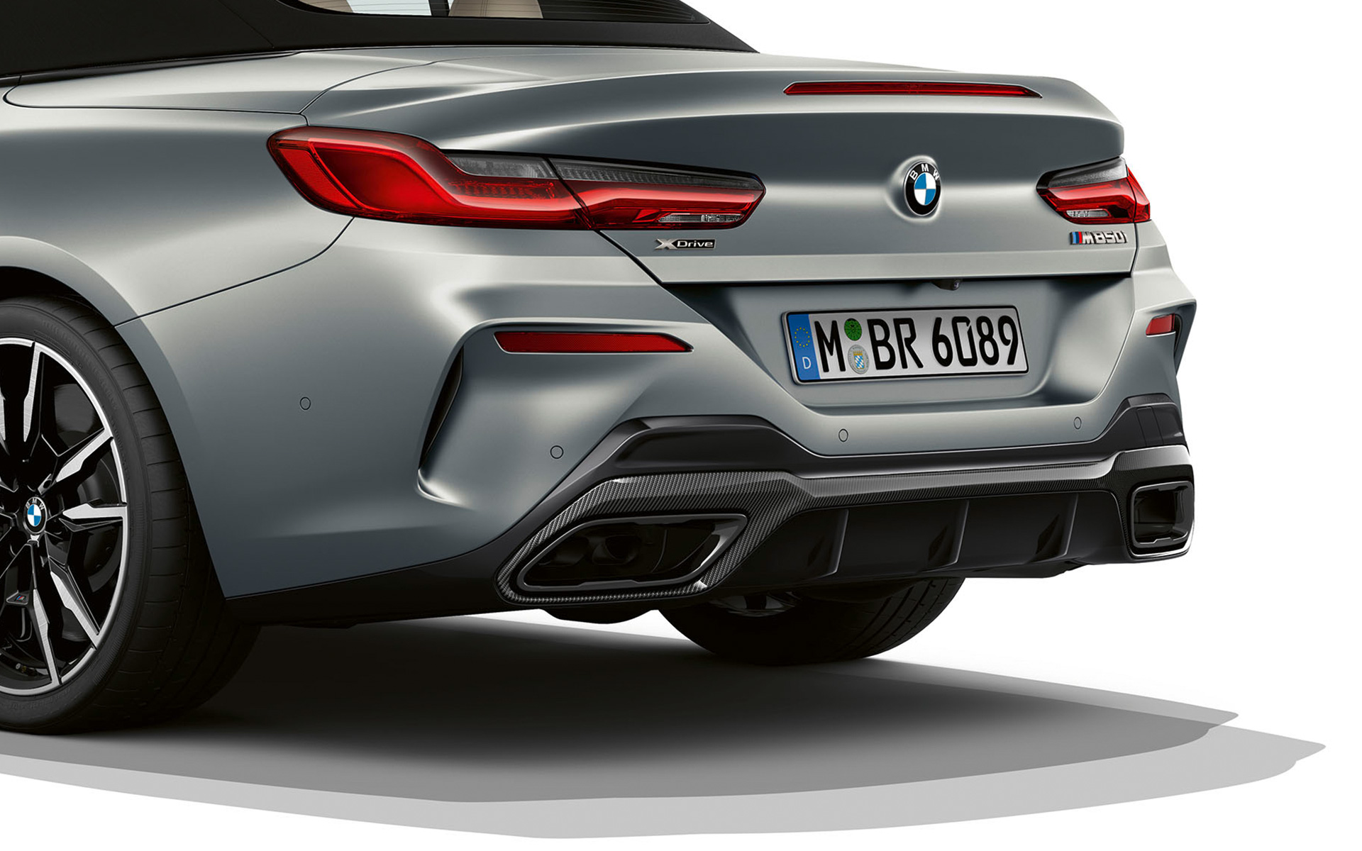 Вид ззаду на три чверті на задній бампер BMW M850i xDrive Cabrio G14 LCI Facelift 2022 BMW М850і xDrive Cabrio G14 LCI Facelift 2022 у кольорі BMW Individual Frozen Pure Grey metallic, вид ззаду на три чверті на задній бампер зблизька