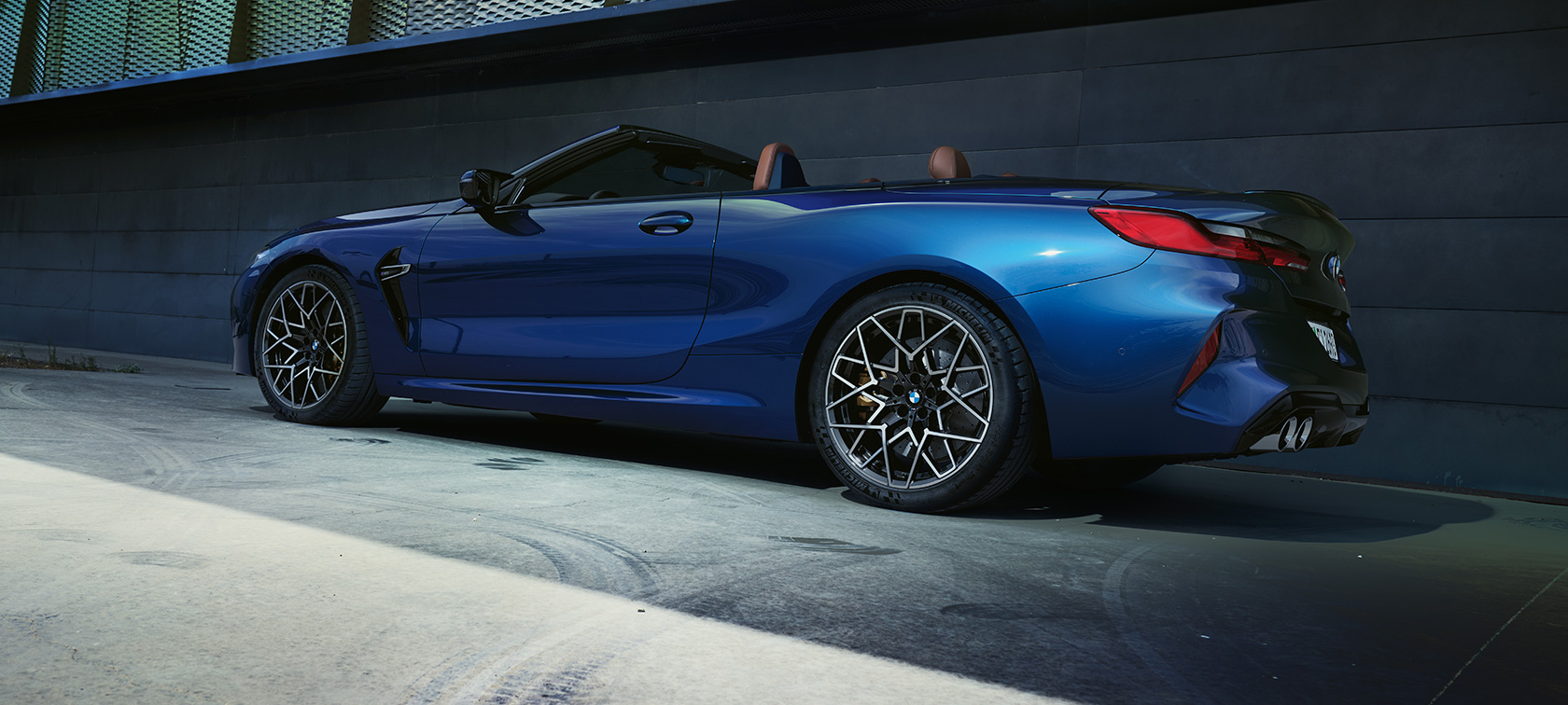 Вид ззаду на три чверті BMW M8 Cabrio F91 LCI Facelift 2022 BMW M8 Cabrio F91 LCI Facelift 2022 кольору BMW Individual Тanzanite blue metallic, вид на три чверті ззаду