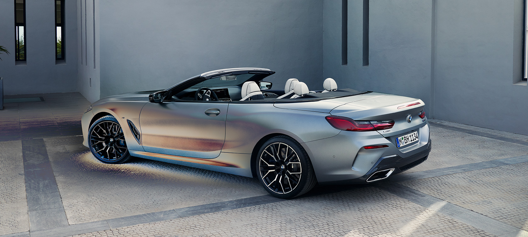 Вид ззаду на три чверті BMW M850i xDrive Cabrio G14 LCI Facelift 2022 BMW М850і xDrive Cabrio G14 LCI Facelift 2022 у кольорі BMW Individual Frozen Pure Grey metallic, вид ззаду на три чверті