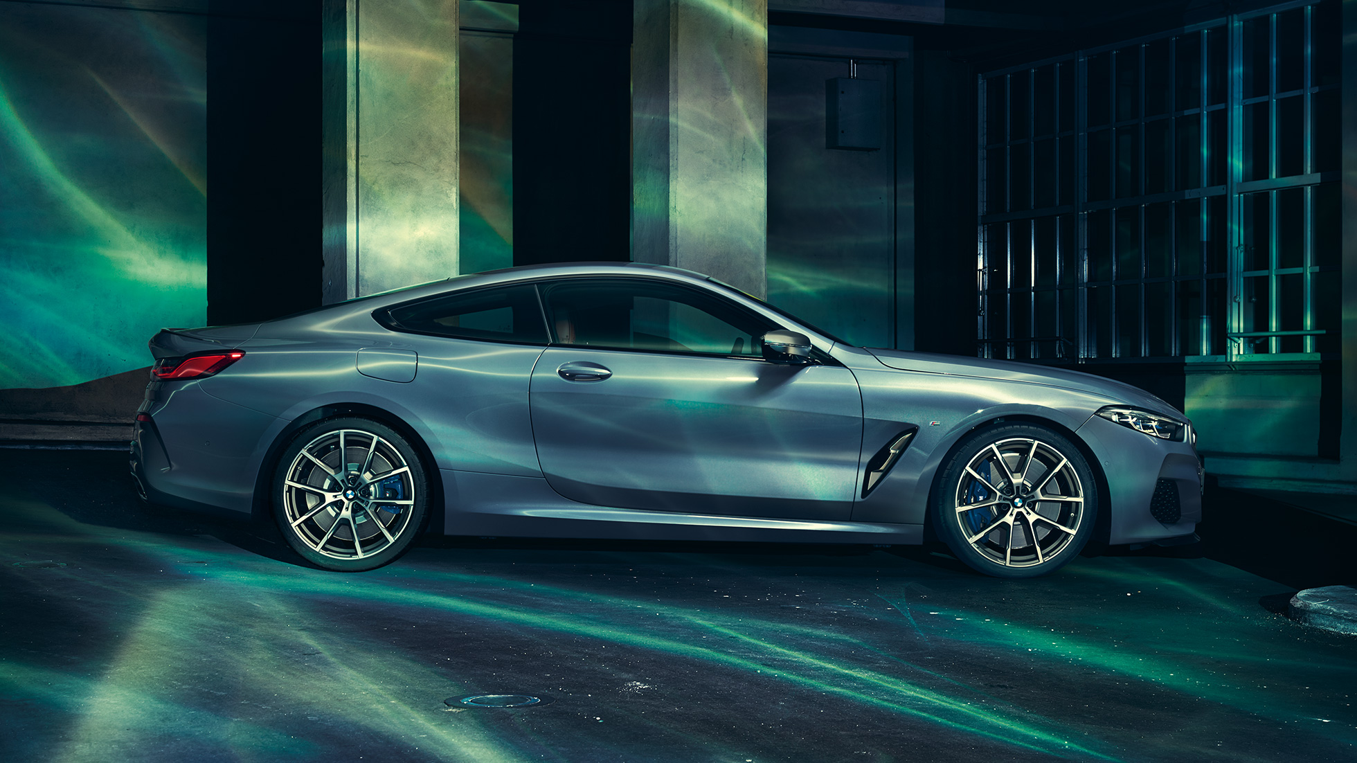 BMW M850i xDrive Coupé, вид збоку. BMW M850i xDrive Coupé в Barcelona Blue металік, вид збоку, перед будівлею.