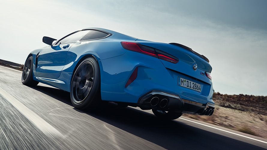 BMW M8 Competition Coupe F92 LCI Facelift 2022 у кольорі BMW Individual Daytona Beach Blue, вид ззаду на три чверті під час руху на шосе