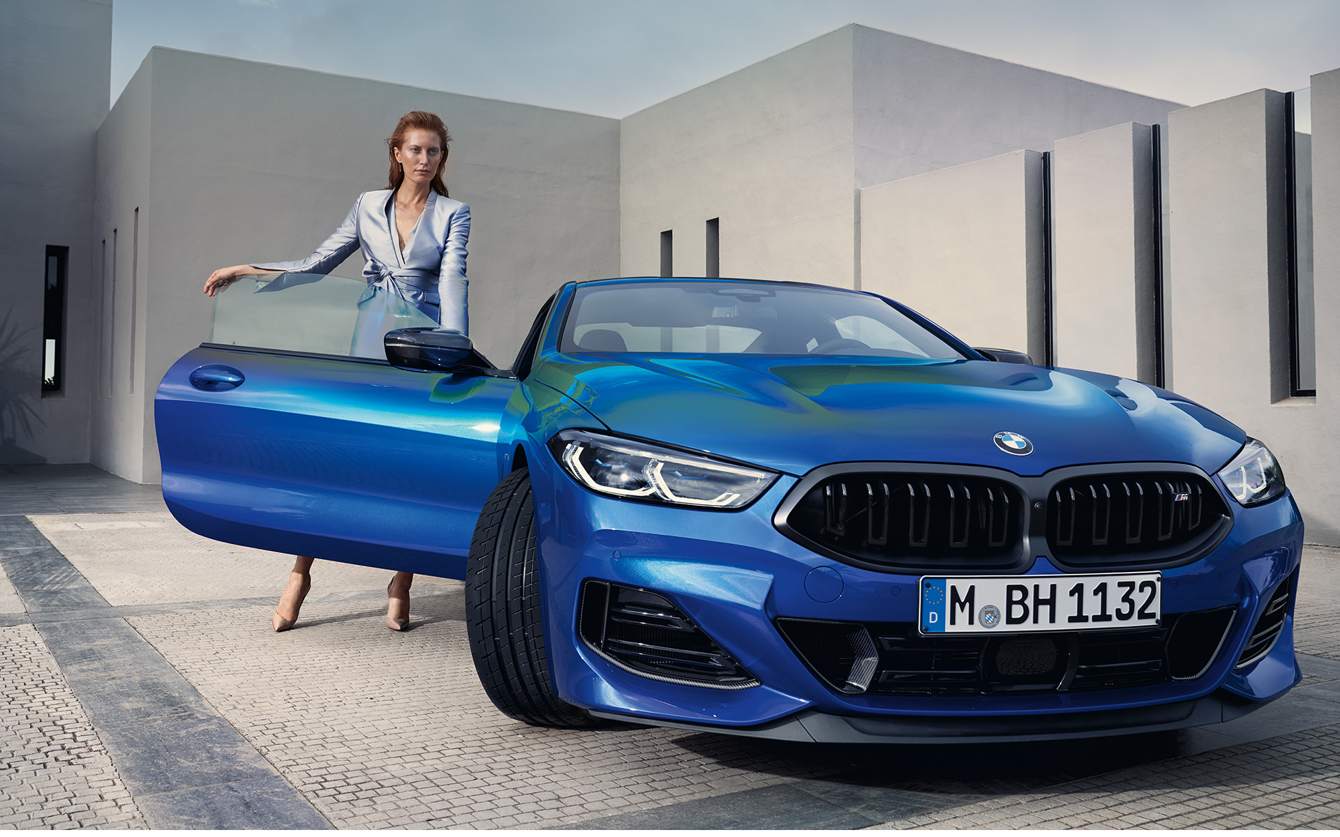 BMW M850i xDrive Coupe G15 Facelift LCI вид спереду BMW xDrive Coupe G15 LCI Facelift 2022 M у кольорі Portimao Blue metallic, вигляд спереду з моделлю та відкритими передніми дверима