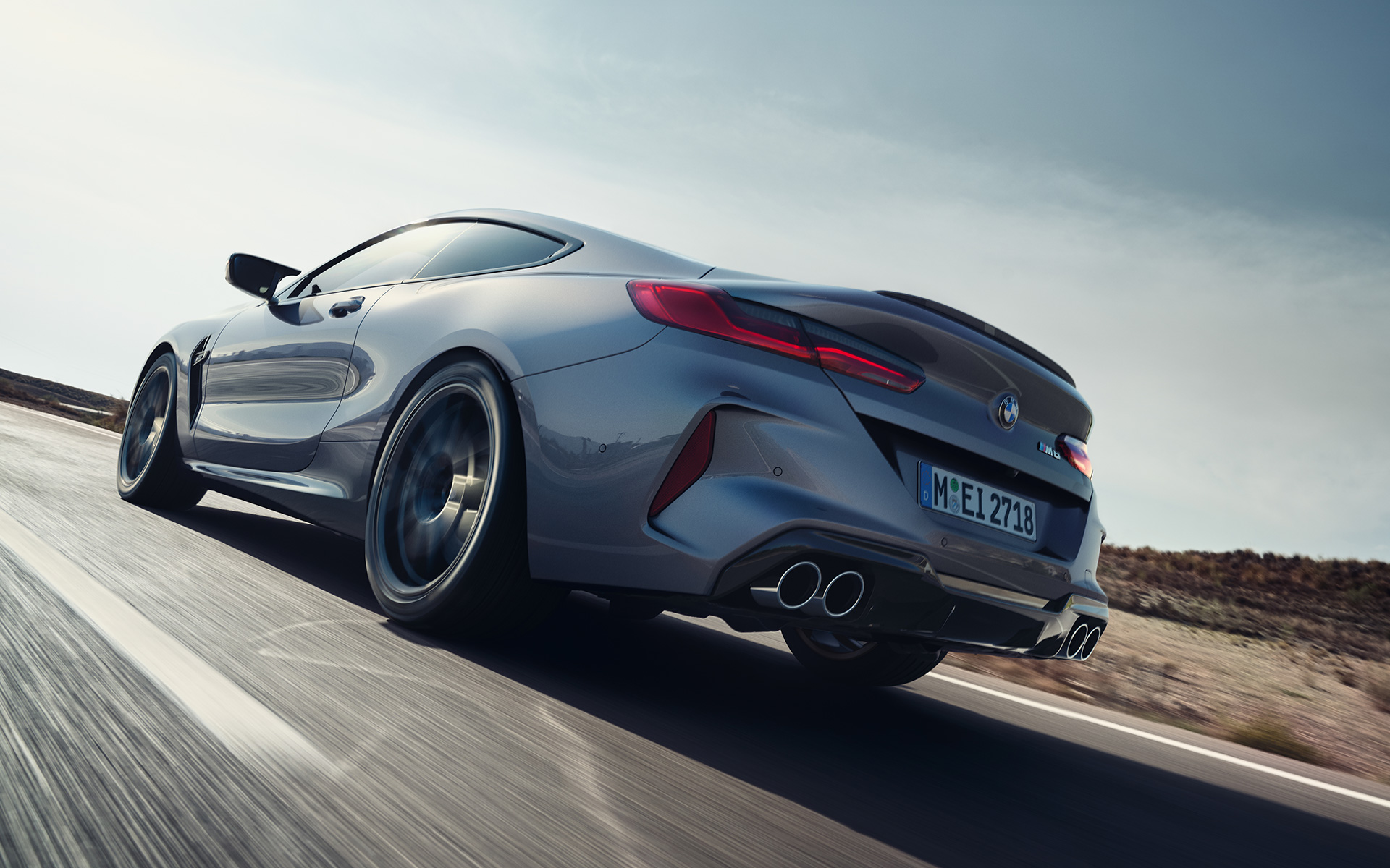 Вид спереду на три чверті BMW M8 Coupe F92 LCI Facelift 2022 під час їзди на шосе BMW M8 Сoupe F92 LCI Facelift 2022 кольору Skyscraper grey metallic, вид ззаду на три чверті знизу під час їзди
