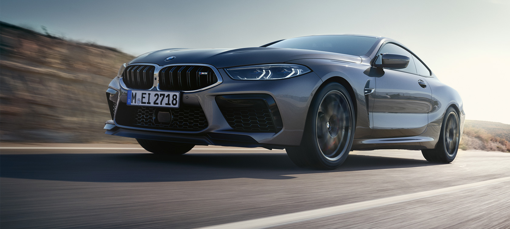 BMW M8 Сoupe F92 LCI 2022 вид на три чверті збоку під час руху BMW M8 Сoupe F92 LCI Facelift 2022 кольору Skyscraper grey metallic, вид збоку на три чверті знизу