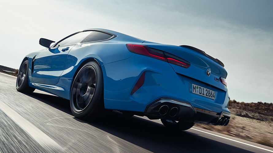 BMW M8 Competition Coupe F92 LCI 2022 вид ззаду на три чверті під час руху BMW M8 Competition Coupe F92 LCI Facelift 2022 у кольорі Daytona Beach Blue, вид ззаду на три чверті під час руху