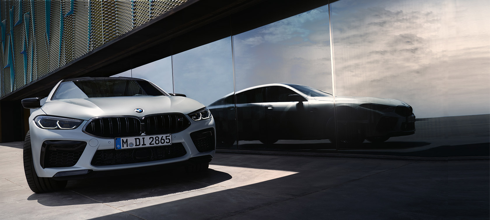 Передня частина BMW M8 Competition Gran Coupe F93 LCI Facelift 2022 BMW M8 Gran Coupe F93 LCI Facelift 2022 у кольорі BMW Individual Frozen Brilliant White metallic, вид спереду з відображенням силуету на передній частині вікна
