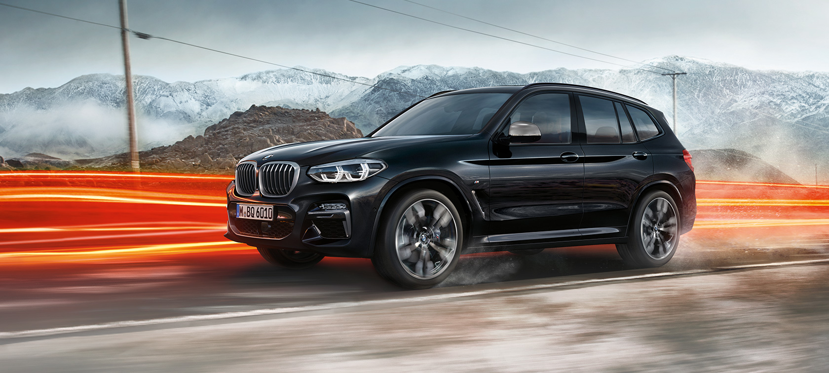 BMW X3 M40i і BMW X3 M40d, вид збоку. BMW X3 M40i і BMW X3 M40d в Black Sapphire металік, за кермом, екстер'єр, вид збоку перед гірським пейзажем зі світловими смугами.