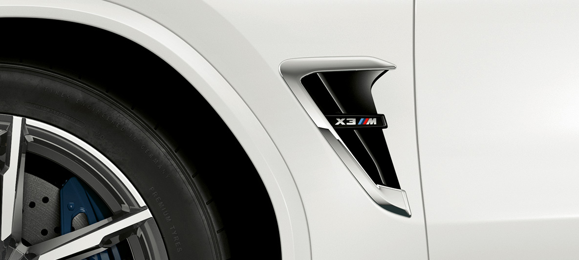 BMW X3 M, зябра M. BMW X3 M в Alpine White, екстер'єр, зябра M з хромованими вставками і позначенням моделі.