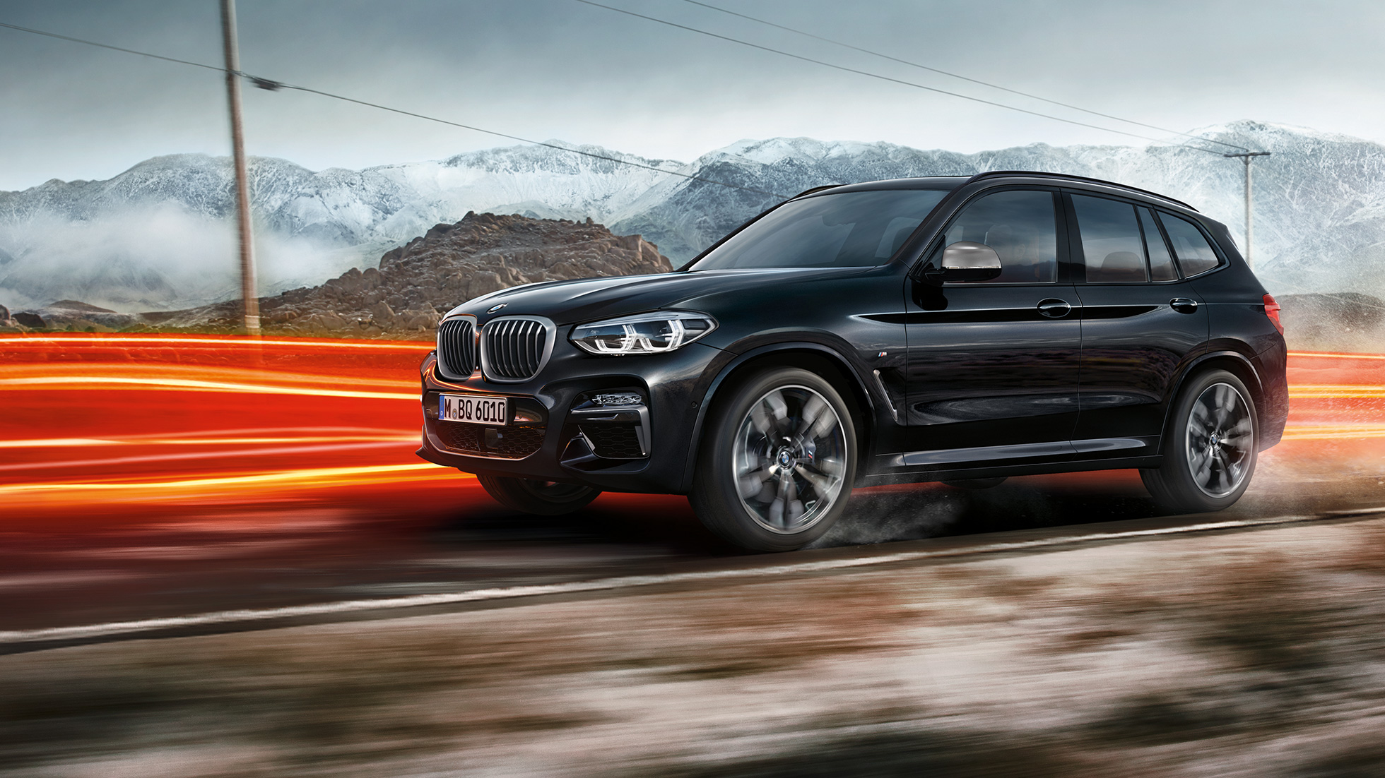 BMW X3 M40i та BMW X3 M40d, вид збоку. BMW X3 M40i та BMW X3 M40d у Black Sapphire металік, за кермом, екстер'єр, вид збоку перед горним пейзажем зі світловими смужками.