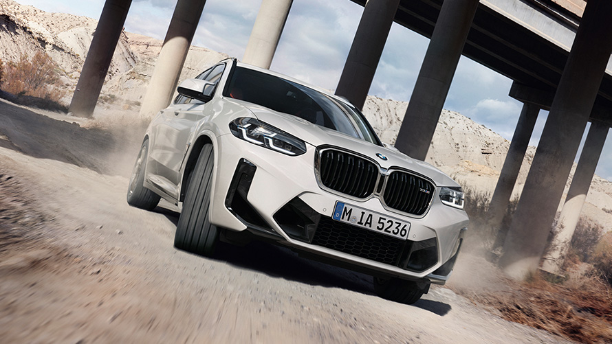 BMW X3 M F97 LCI Facelift 2021 в кольорі Alpine White, вид спереду в три чверті на повороті BMW X3 M F97 LCI Facelift 2021 в кольорі Alpine White, вид спереду в три чверті на повороті