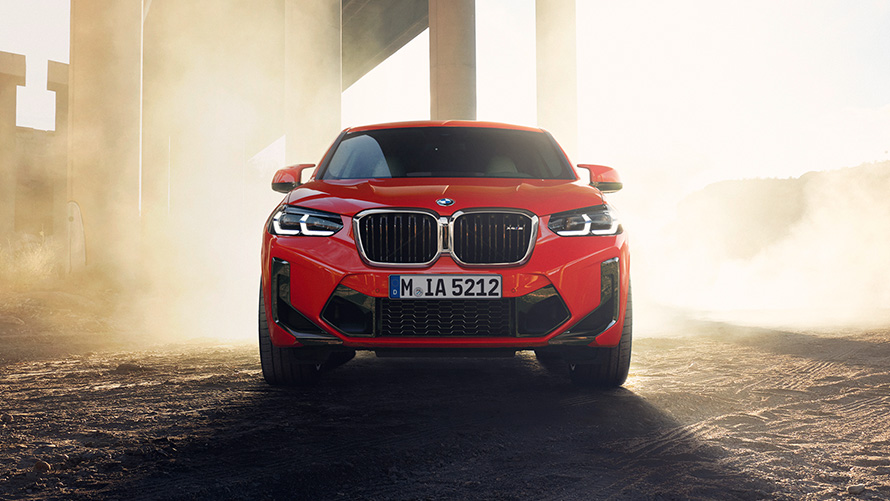 BMW X4 M F98 LCI Facelift 2021 в кольорі Toronto Red металік, вид спереду перед колонами моста