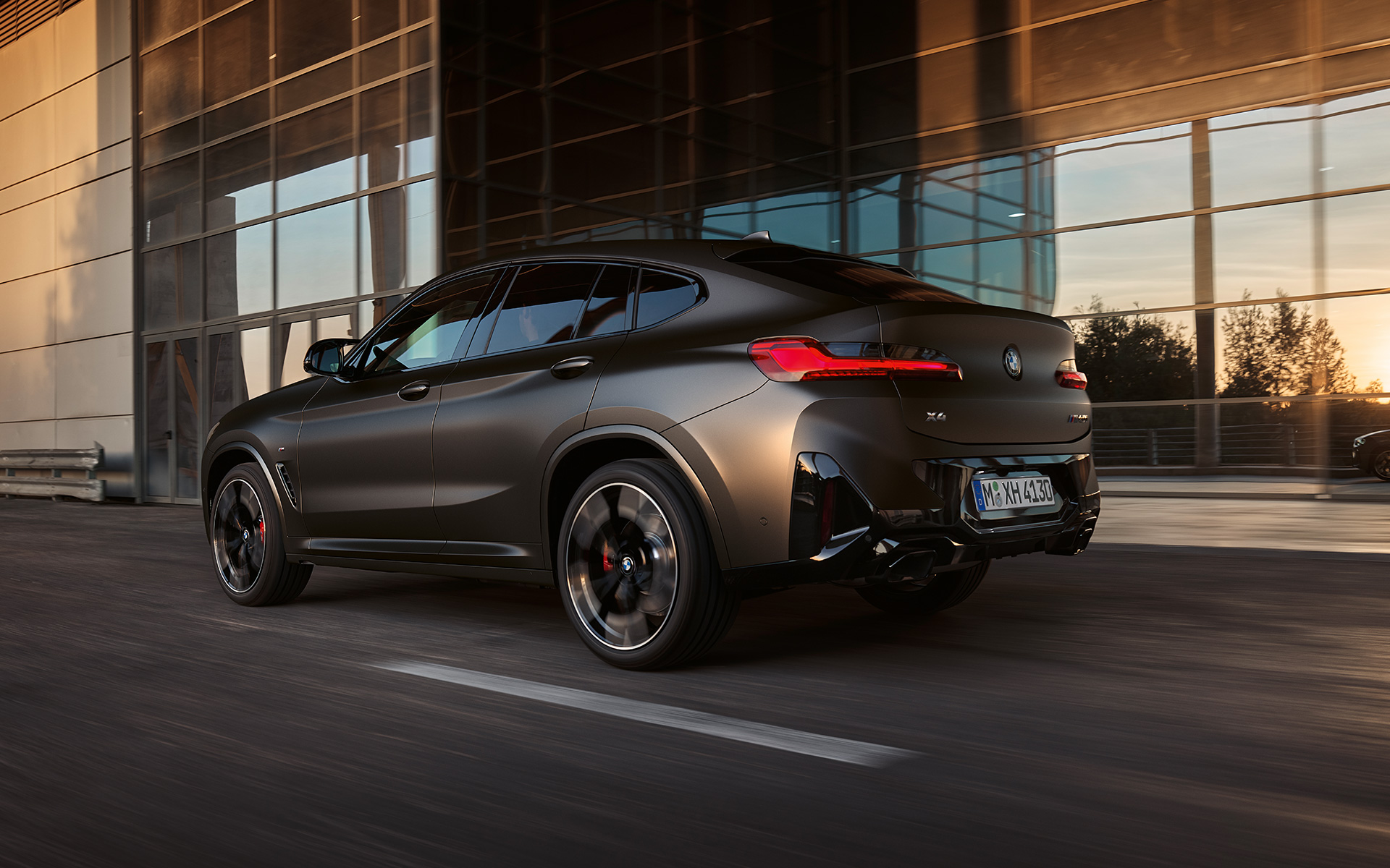 BMW X4 M40i G02 LCI 2021 Facelift, вид ззаду в три чверті перед скляним фасадом