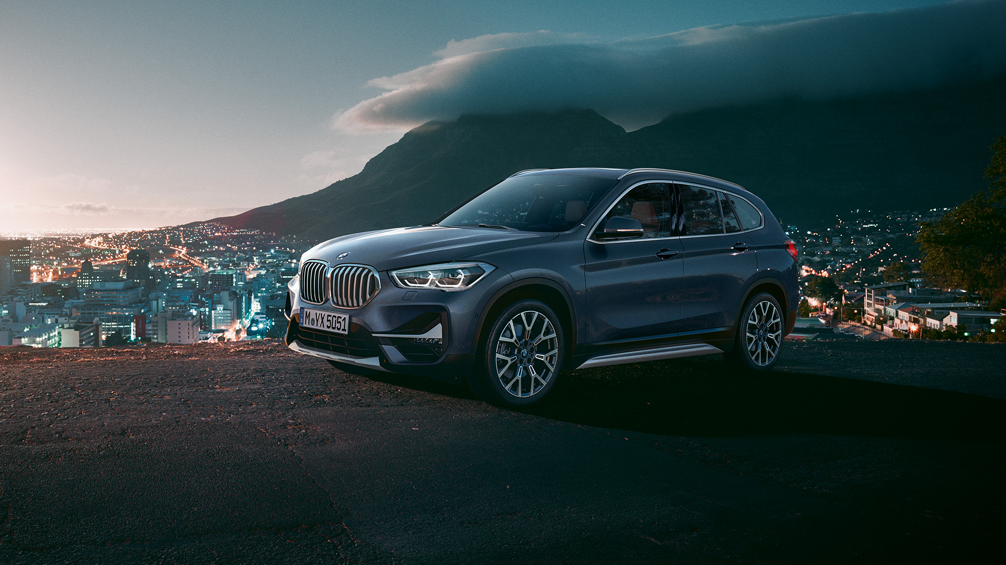 BMW X1, вид збоку з поворотом в три чверті. BMW X1, вид збоку з поворотом в три чверті на тлі міського пейзажу.