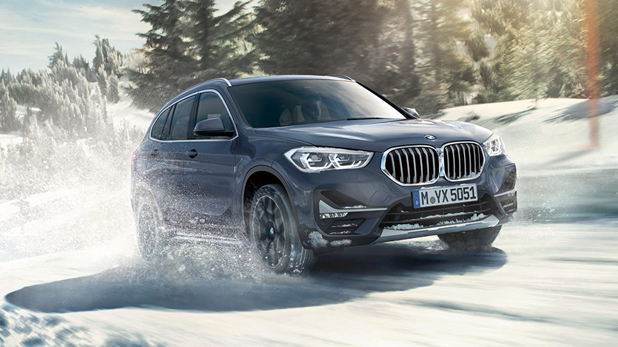 BMW X1 xDrive20i F48 LCI в цвете BMW Individual Storm Baymetallic, в движении на зимнем пейзаже BMW X1 xDrive20i F48 LCI в цвете BMW Individual Storm Baymetallic, в движении на зимнем пейзаже