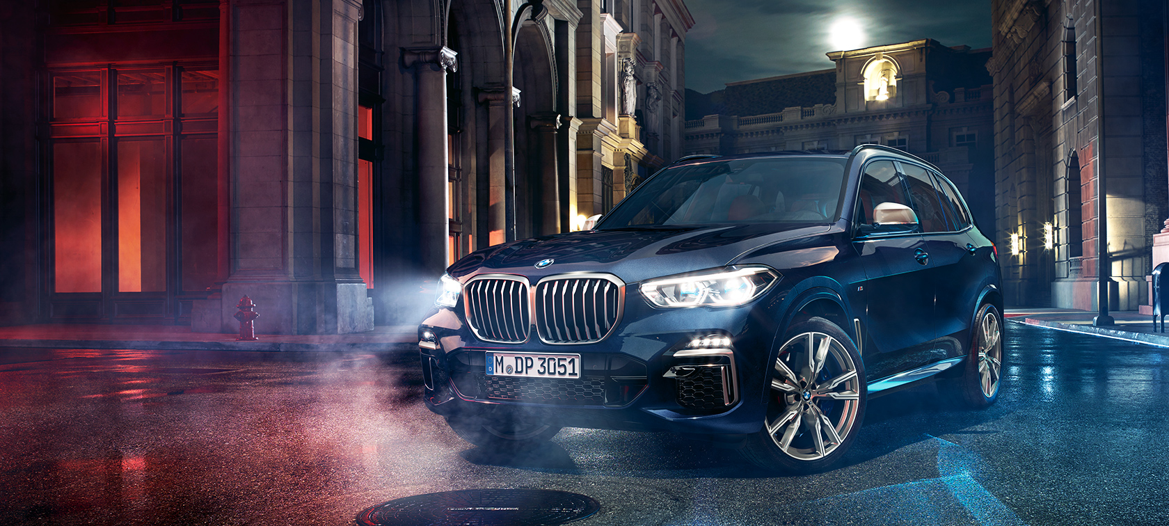 BMW X5 M50d на дорозі BMW X5 M50d стоїть на дорозі на тлі нічного міста