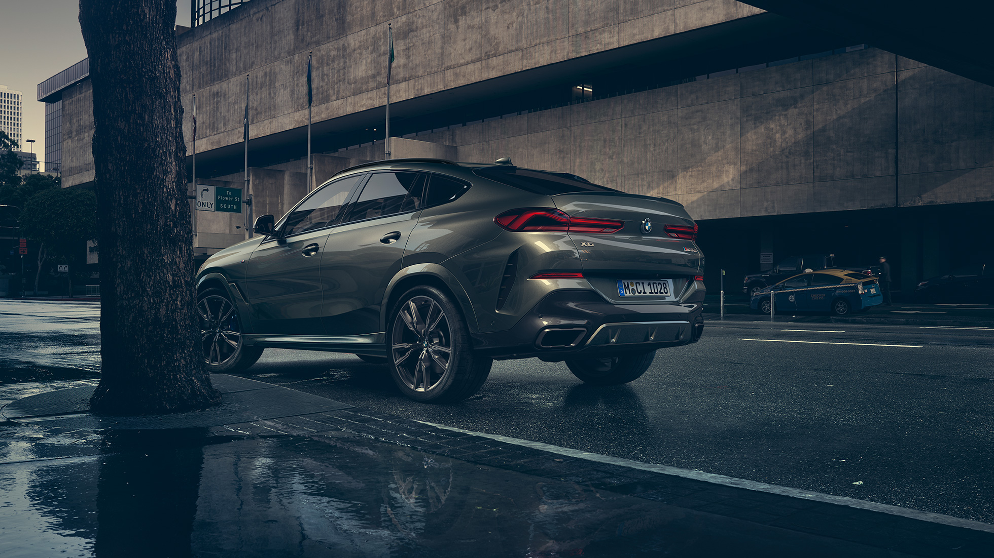 Екстер’єр BMW X6. BMW X6, вид ззаду з поворотом в три чверті плані перед міською обстановкою.