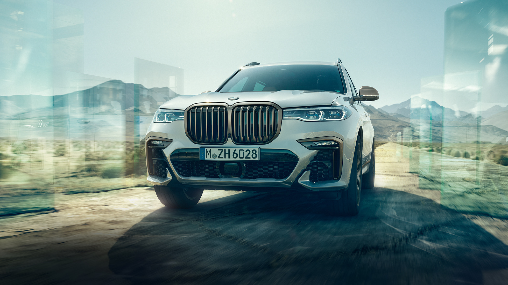 BMW X7 M50d: низкоуровневый снимок вождения BMW X7 M50d: наклонный низкоуровневый снимок вождения, белый BMW X7