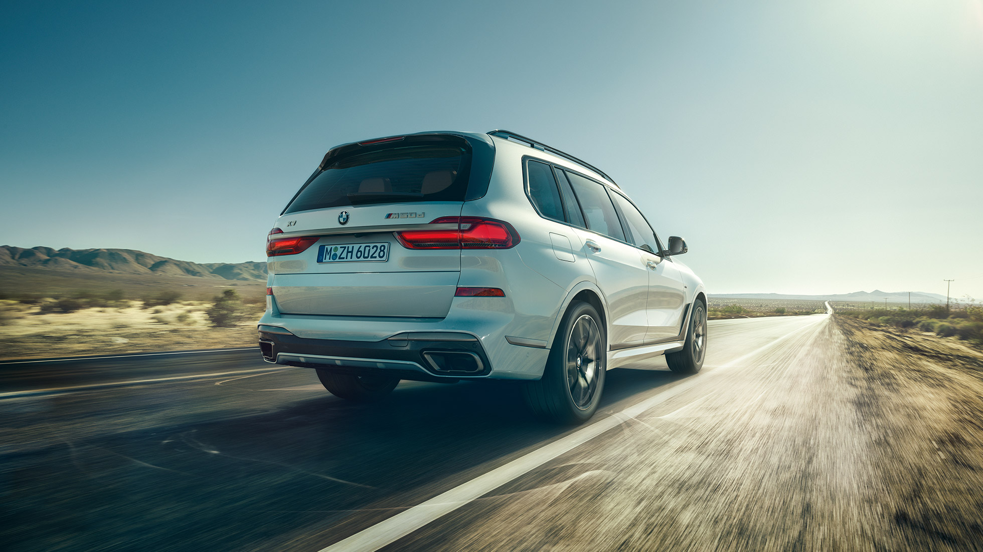 BMW X7 M50d: задний снимок BMW X7 M50d: задний снимок вождения, белый BMW X7