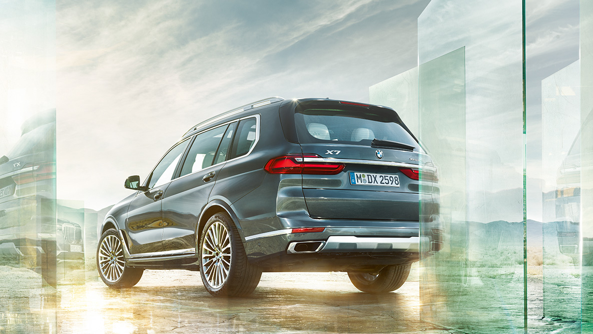 BMW X7 Комфорт и динамика вождения BMW X7 вид сзади три четверти перед абстрактным фоном