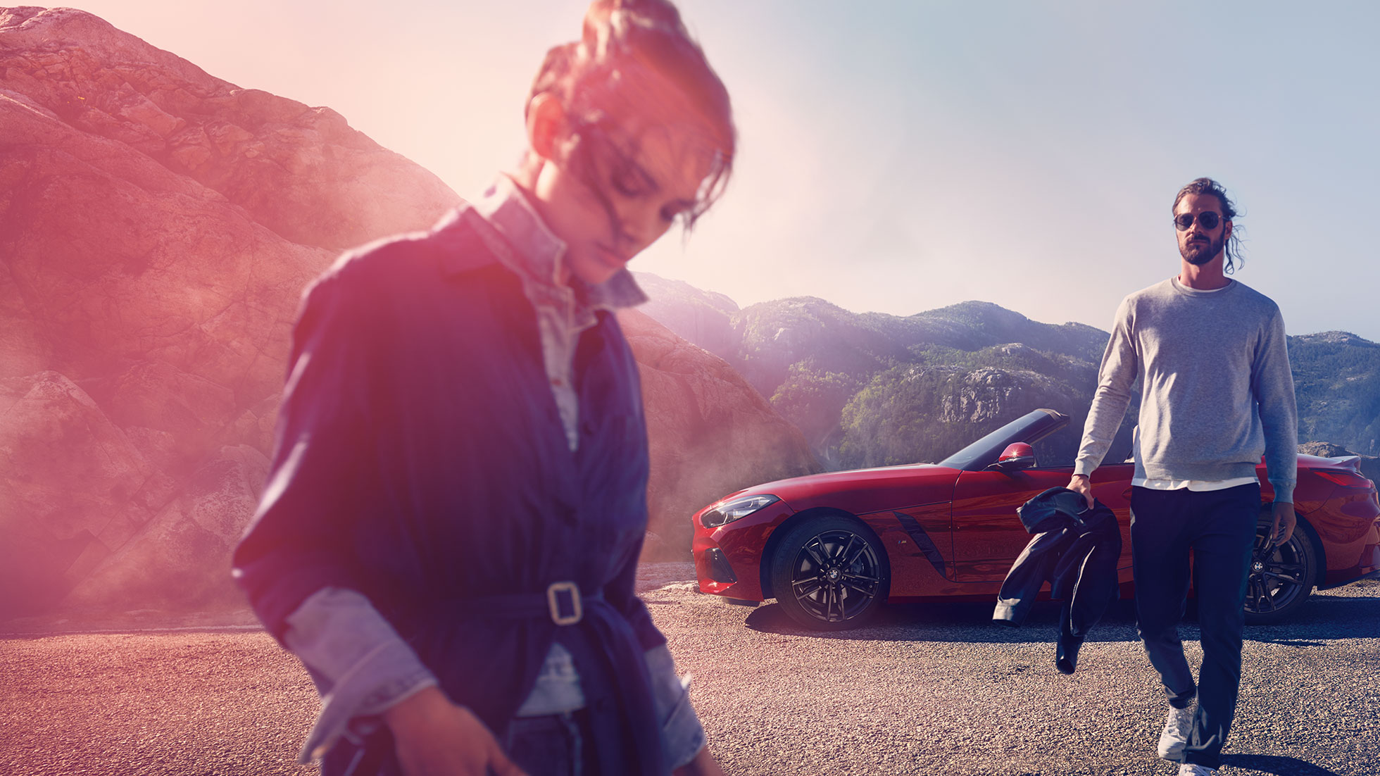 BMW Z4 Родстер перед видом на горы Мужчина с женщиной и BMW Z4 Roadster перед видом на горы
