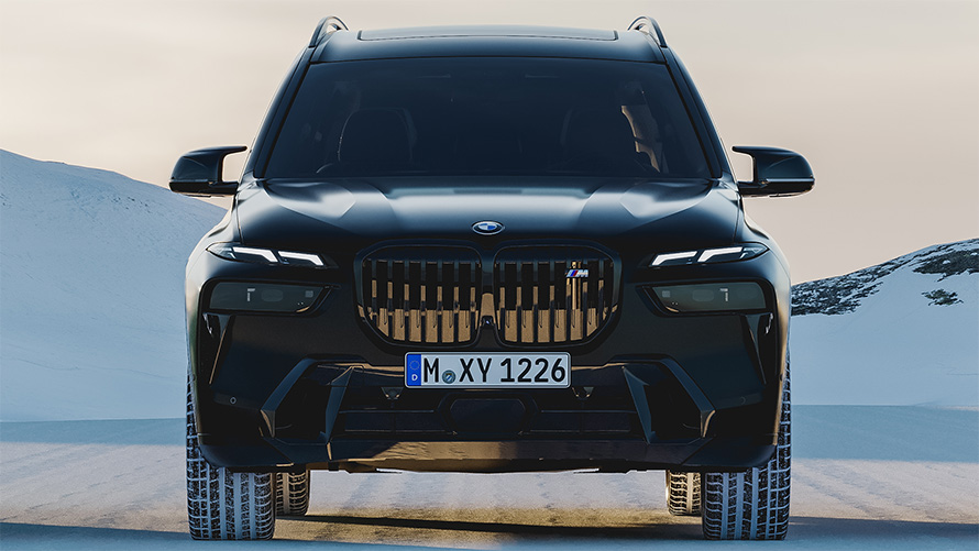 BMW X7 G07 в кольор BMW Individual Frozen Black, вид спереду, припаркований на снігу.
