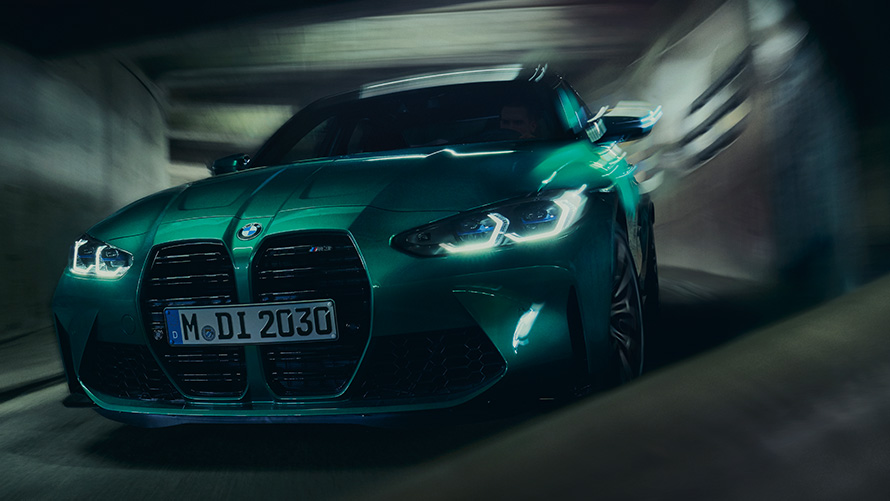 BMW M3 Competition Седан G80 2021 у кольорі BMW Individual Isle of Man Green metallic, вид спереду в три чверті в русі на повороті