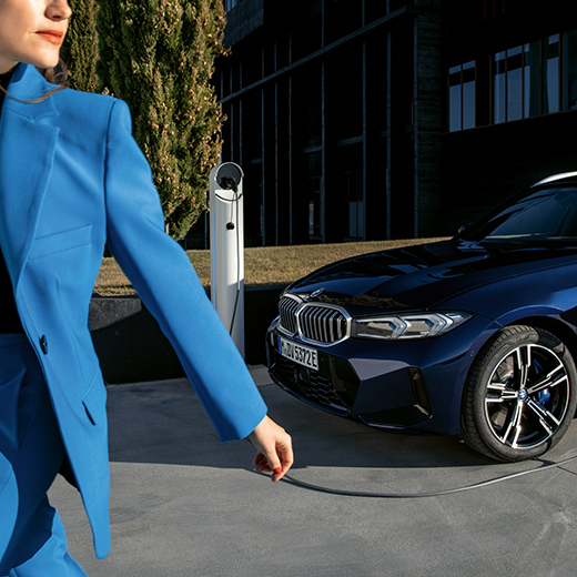 BMW заряджається з жінкою, яка рухається на передньому плані