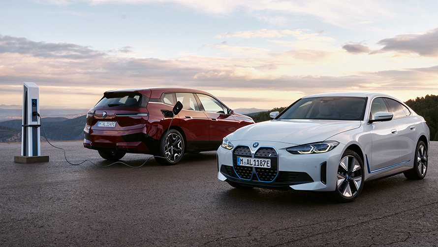 Серія BMW BEV, Концепція екологічності BMW Концепція екологічності BMW, Серія BMW BEV, два автомобілі BMW стоять поруч із зарядною станцією