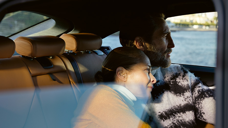 Жінка та чоловік сидять у BMW та дивляться у вікно BMW Repair Inclusive. Жінка та чоловік сидять у BMW та дивляться у вікно