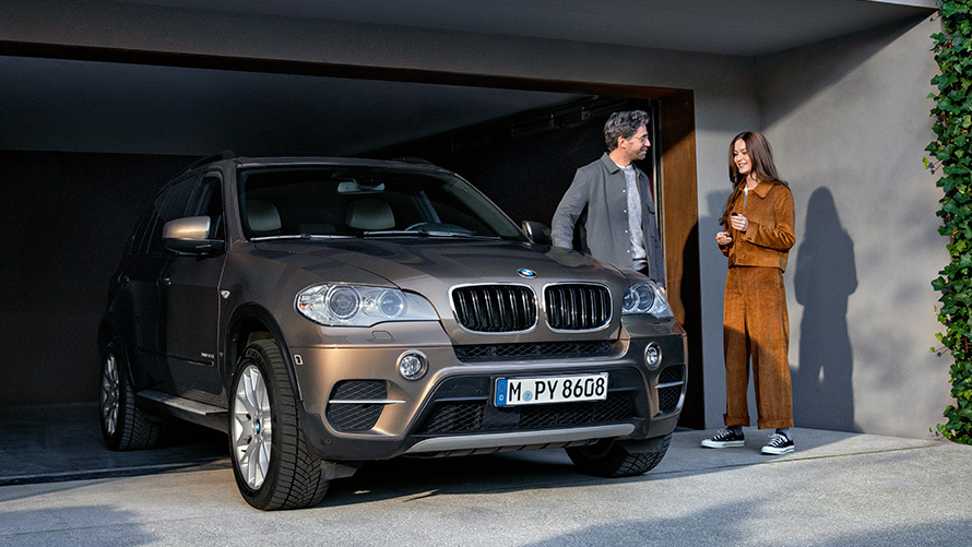 BMW стоїть перед гаражем з моделями BMW Value Service, BMW стоїть перед гаражем з моделями